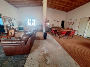 a living room with a leather couch and a table at Cabaña Marmolejo in Arteaga