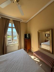 a bedroom with a bed and a mirror and a window at Hotel Palacio de las Nieves in Langreo