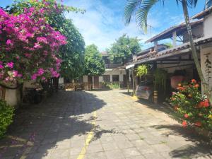 a street in front of a building with flowers at Solemar in Guarapari
