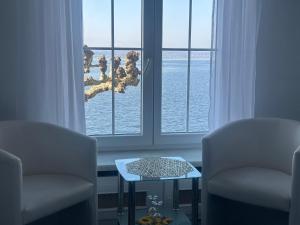a room with two chairs and a table in front of a window at Hotel la Perla in Meersburg +15 photos