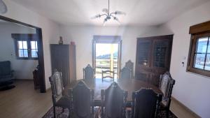 a dining room with a table and chairs and a window at Casa das Quintas com vista para a montanha in Boticas +10 photos