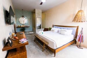 a bedroom with a bed and a table and a desk at Hotel Siesta Holbox in Holbox Island