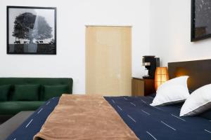 a bedroom with a bed and a green couch at Casa María Guest House in Santa Cruz Etla