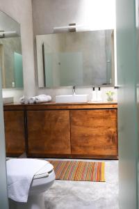 a bathroom with a sink and a toilet and a mirror at Casa María Guest House in Santa Cruz Etla