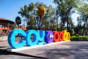 a sign that says wow in front of a park at Suites CDMX in Mexico City