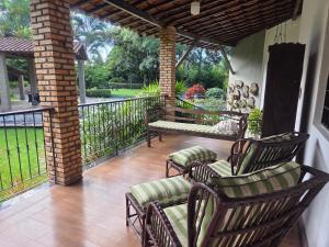 a porch with chairs and a table and a balcony at Flat 02 Carvalhos de Aldeia in Recife