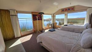 a bedroom with two beds and a view of the water at Uros Sunset Lodge in Puno +6 photos