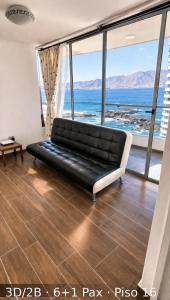 a black couch in a room with a view of the ocean at Departamentos Nautilus in Iquique +69 photos
