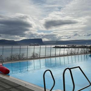 a swimming pool with a view of a body of water at Sigtun 55 in Patreksfjörður