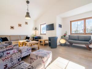 a living room with two couches and a tv at Haus Bergblick in Westendorf