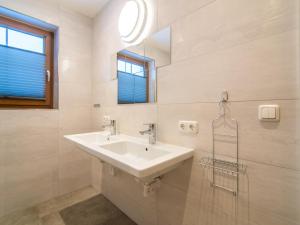 a white bathroom with a sink and a mirror at Haus Bergblick in Westendorf +27 photos