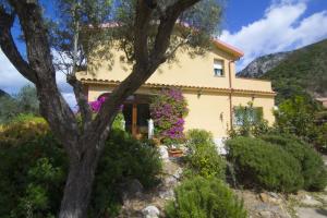 una casa en las montañas con flores en Agriturismo Sa Rocca, en Iglesias