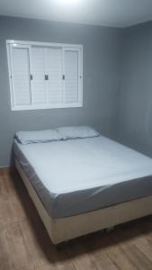 a bed in a room with white cabinets at Suites Clarinda in Capitólio
