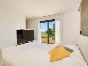 a bedroom with a large bed with a large window at Vue Saint Tropez in Grimaud