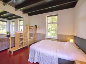 a bedroom with a large white bed and windows at t Voorhuis Kolderveen in Nijeveen