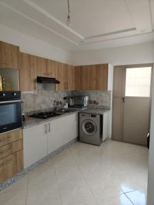 a kitchen with white cabinets and a washer and dryer at Khouribga in Khouribga