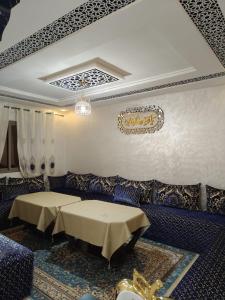 a dining room with two tables and a couch at Khouribga in Khouribga