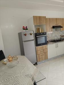 a kitchen with a refrigerator and a table in it at Khouribga in Khouribga