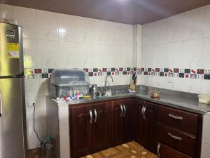 a kitchen with a sink and a refrigerator at Posada el arrecife in Nuquí +5 photos