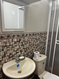 a bathroom with a sink and a toilet and a mirror at Posada el arrecife in Nuquí