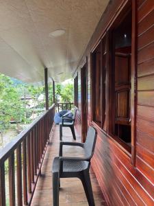 two chairs sitting on the porch of a house at Posada el arrecife in Nuquí