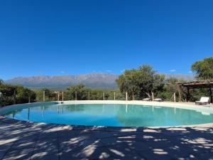a large swimming pool with mountains in the background at Casa Nidito San Javier in San Javier