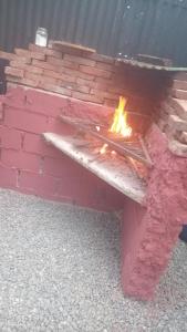 a bench with a fire in a brick wall at Refugio del Pirata Algarrobo in San Antonio