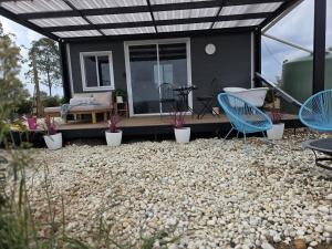 a house with a patio with chairs and a table at Whispering Vines in Lovedale +1 photo