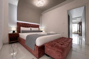 a bedroom with a large bed and a brown tufted couch at Candi Luxury Suites 2 in Neos Marmaras