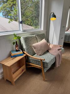 a room with a chair and a table and a window at Tiny Escape in Lennox Head