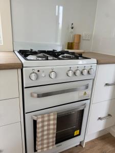 a white stove top oven in a kitchen at Tiny Escape in Lennox Head +14 photos