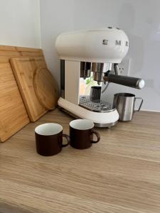 two coffee cups sitting on the floor next to a mixer at Tiny Escape in Lennox Head