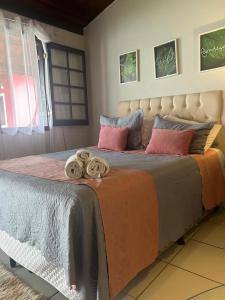 a bedroom with a large bed with blankets and pillows at Vila Noel Centro in Penedo