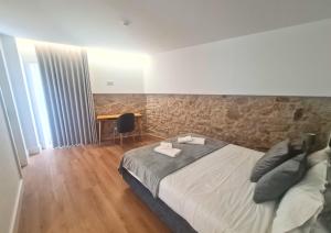 a bedroom with a large bed and a stone wall at Quinta das Aromáticas in Malta +81 photos