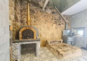 a room with a stone wall with a fireplace at Quinta das Aromáticas in Malta