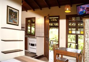 Una cocina con una mesa y un comedor. en Pousada Florence, en Ilhabela