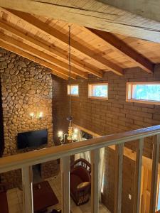 a room with a stone wall with a tv and a ceiling at Cabaña Cuevas Tapalpa in Tapalpa