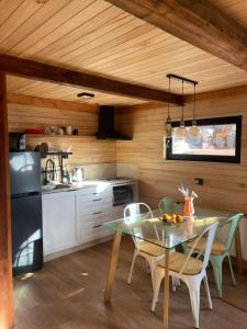 a kitchen with a table with chairs and a refrigerator at Tiny Under Chalet in Santiago