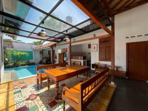 a dining room with a table and a pool at Sabi House Kates in Timuran