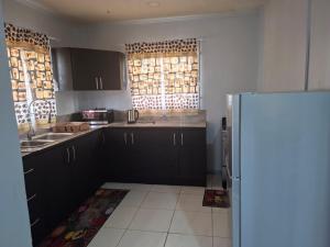a kitchen with black cabinets and a refrigerator at Zara Appartement in Paramaribo