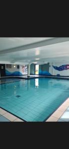 a large swimming pool in a large building at Aurora luxury beach lodge in Lossiemouth