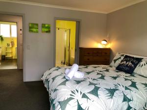 a bedroom with a bed with a stuffed animal on it at Modern Spacious Manapouri Home in Manapouri +2 photos