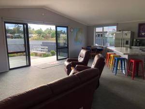 a living room with a couch and a kitchen with a table at Modern Spacious Manapouri Home in Manapouri