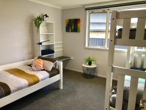 a small bedroom with a bunk bed and a ladder at Modern Spacious Manapouri Home in Manapouri