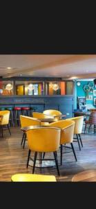 a dining room with yellow chairs and tables at Aurora luxury beach lodge in Lossiemouth