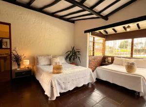 a bedroom with two beds and a window at La Franchesca Hotel Boutique in Tabio