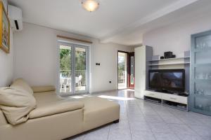 a living room with a couch and a television at Adria Holiday Home in Pinezici