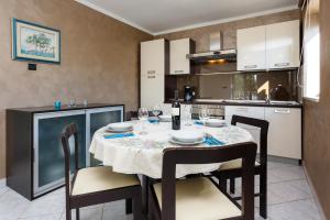 a kitchen and dining room with a table and chairs at Adria Holiday Home in Pinezici