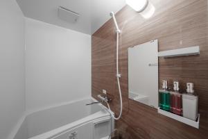 a bathroom with a shower and a mirror at Asahikawa Stay Ecole 101 in Asahikawa