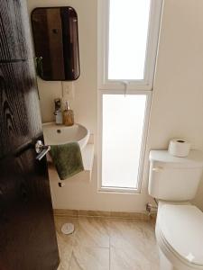 ein Badezimmer mit Toilette, Waschbecken und Fenster in der Unterkunft Casa Mi Chula in Veracruz